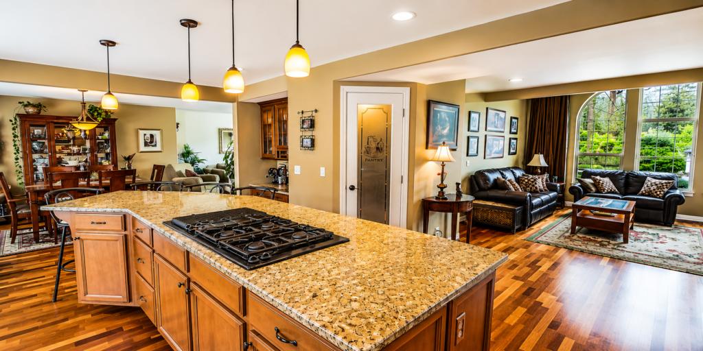 Modern luxury home interior with stylish kitchen island, wooden flooring, elegant lighting, and living room design.